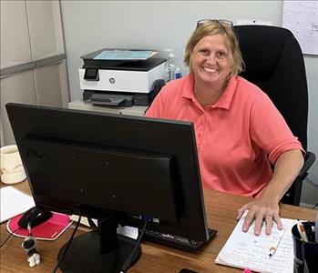 SERVPRO employee sitting at desk